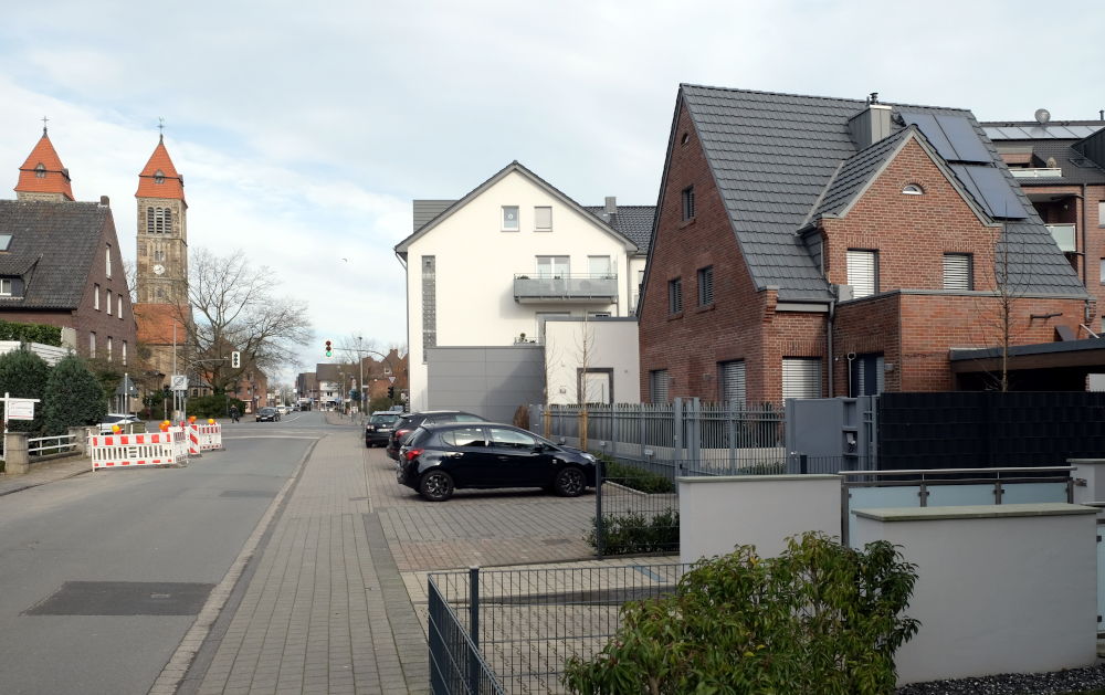 Am Klosterwald 1, das Klinkerhäuschen rechts auf dem Foto, nach der Renovierung. In der Bildmitte der helle Giebel des Textilhauses Grosche, im Vordergrund die Tiefgarageneinfahrt des Nachbarhauses; im Hintergrund links St. Clemens (8.3.2020; Foto: Hennin