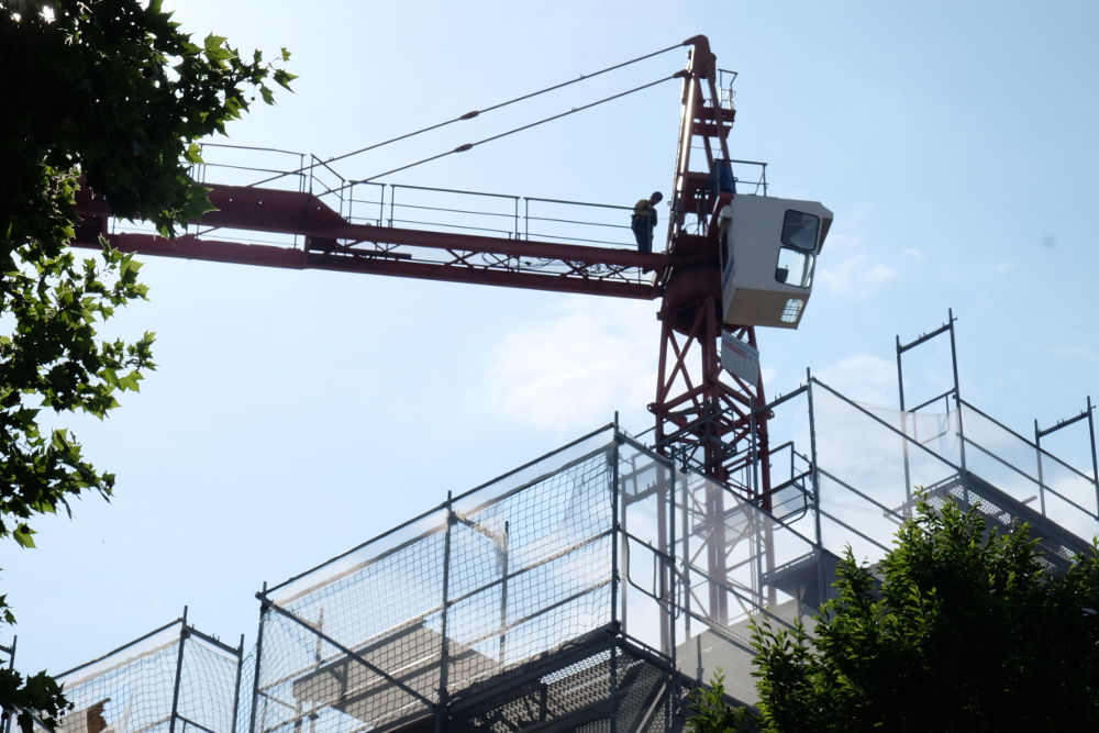 Hoch oben löst der Monteur den kurzen Ausleger vom Kran (28.5.2017; Foto: Klare)