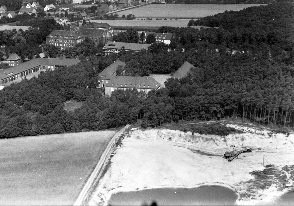 Bildmitte: Polizeischule, dahinter der Neubau des Kardinal-von-Galen-Gymnasiums und das Paterkloster, im Vordergrund die Sandgrube Mertensheide (1950)