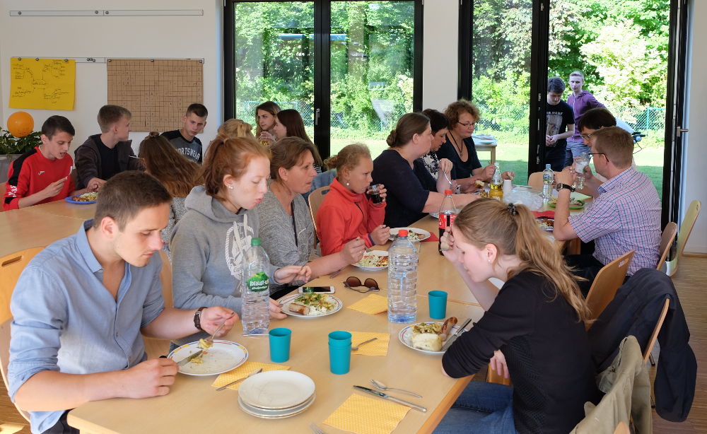 Gemeinsames Essen von Gästen und Gastfamilien im Gemeindezentrum (2.7.2017; Foto: Klare)