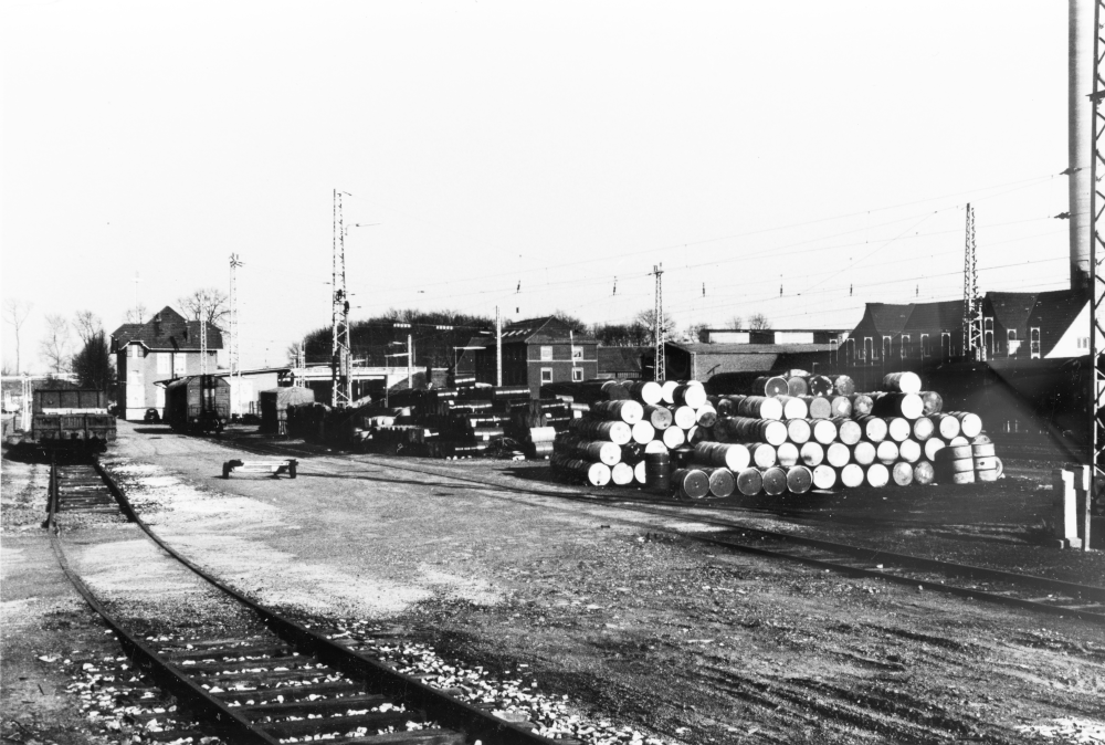 Hiltrup, Bahnhofsgebäude und Güterschuppen mit Glasurit-Industriegleis, im Hintergrund die neue Hochbrücke (um 1982; Foto: Henning Klare)