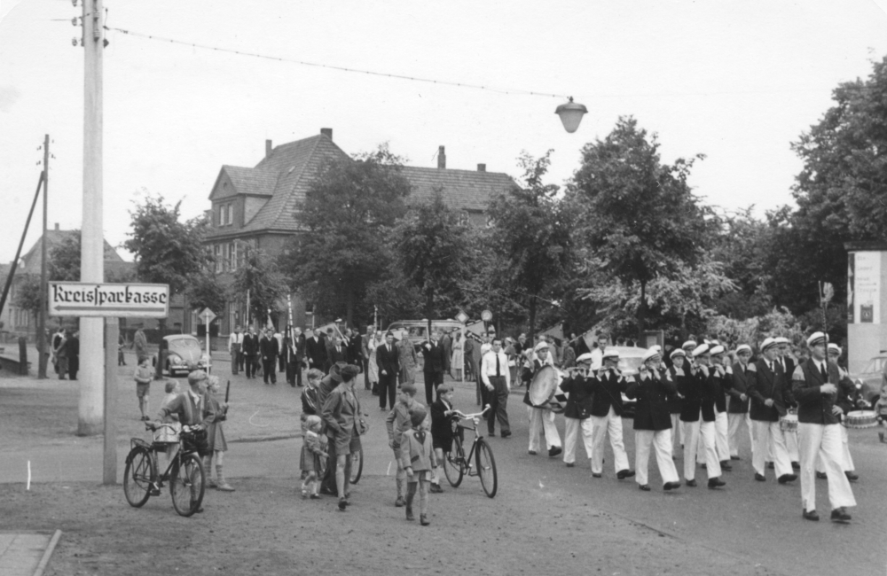 Spielmannszug der Bürgerschützen Hiltrup von 1851 auf der Kreuzung Bahnhofstraße / Klosterstraße, im Hintergrund die Gaststätte Bröker (1954; Foto: Hiltruper Museum)
