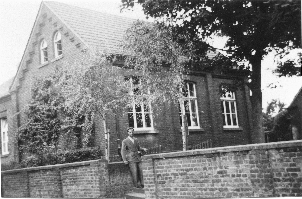 Jakob Giesbert (genannt Geis) Treur 1956 in Hiltrup vor der alten Mädchenschule an der Burchardstraße (heute: An der Alten Kirche. Das Gebäude wurde 1984 abgerissen. Foto: Hiltruper Museum, Bearbeitung: Henning Klare)