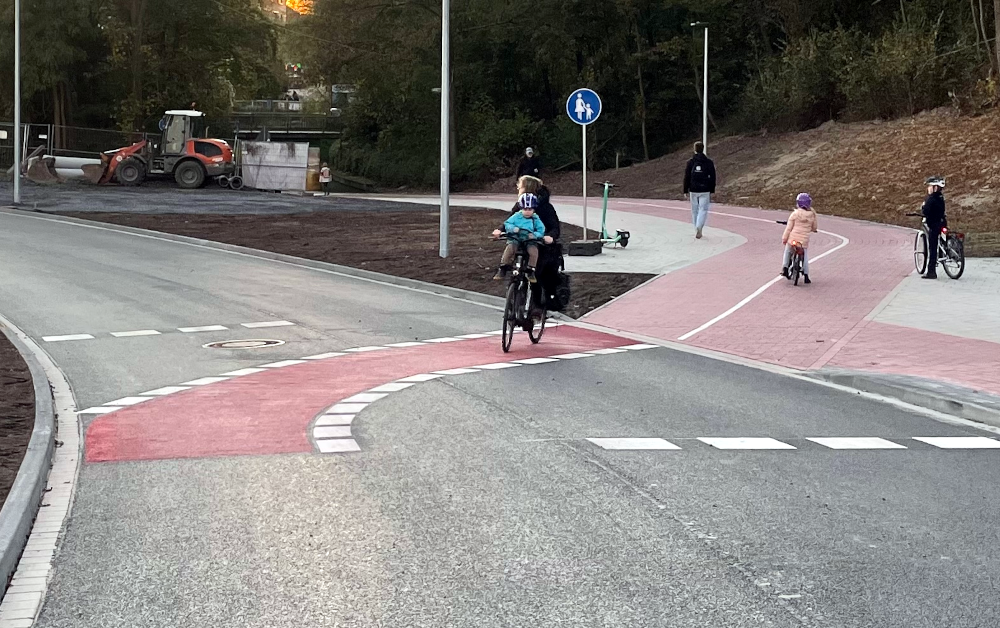 Die Frau mit den zwei Kindern auf ihrem Rad hält die Verkehrsregeln ein (4.11.2024; Foto: Henning Klare)