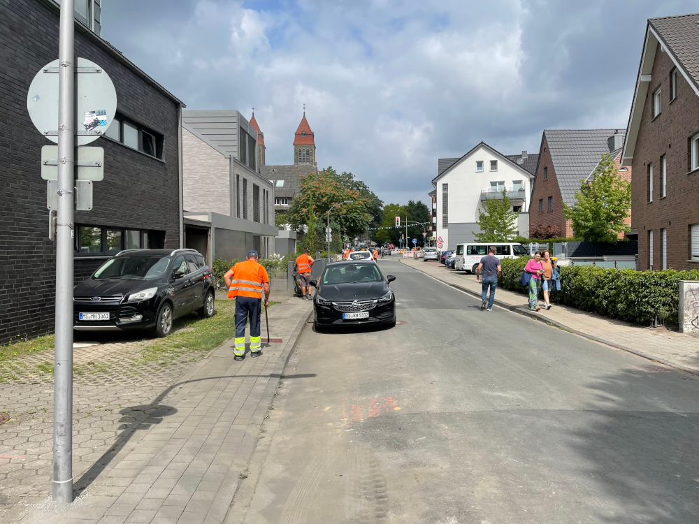 Mit der Rüttelplatte ohne Gehörschutz: Subunternehmer von Visco auf der Straße Am Klosterwald (26.7.2025; Foto: Henning Klare)