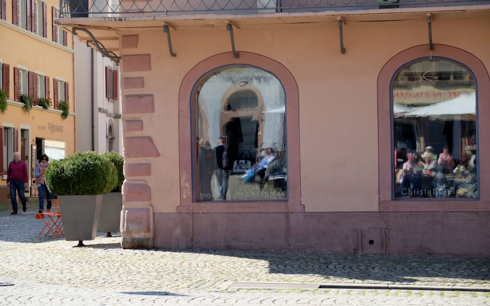 Die Touristen links im Bild sind real, stehen fest auf dem Grund. Das Rathaus spiegelt sich in der Mitte schon recht zerbrechlich, genauso die Kaffeetrinker rechts (Foto: Klare)